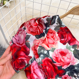 Detail of the one-shoulder neckline and ruffled sleeve of the floral dress.