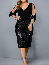 Woman wearing a black and black sequined sheath dress with cold shoulder sleeves and pearl accents