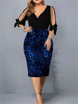 Woman wearing a black and royal blue sequined sheath dress with cold shoulder sleeves and pearl accents