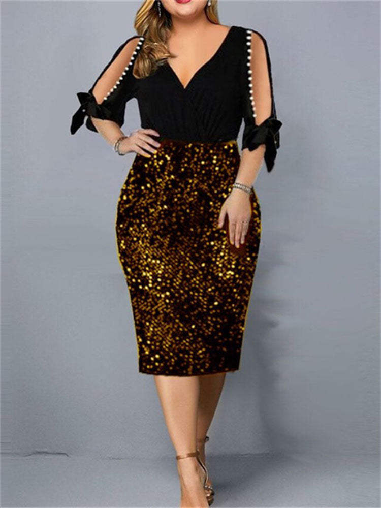 Woman wearing a black and gold sequined sheath dress with cold shoulder sleeves and pearl accents