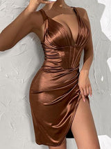 Close-up of a woman's upper body in a brown satin dress with a plunging neckline and high slit, showing jewelry.