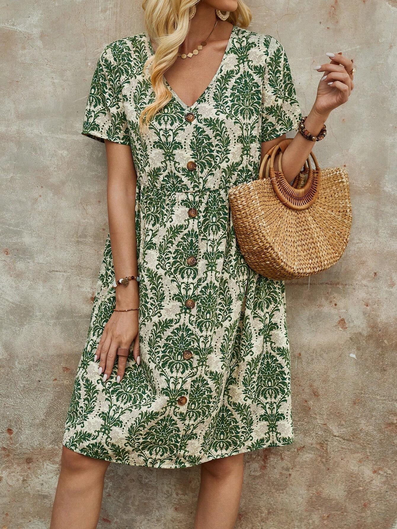 Woman wearing a green and white floral print button-down midi dress with short sleeves and a V-neck, holding a straw handbag.
