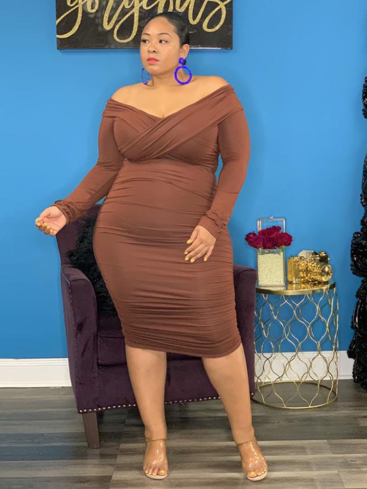 Full body shot of a woman in a brown long-sleeved dress
