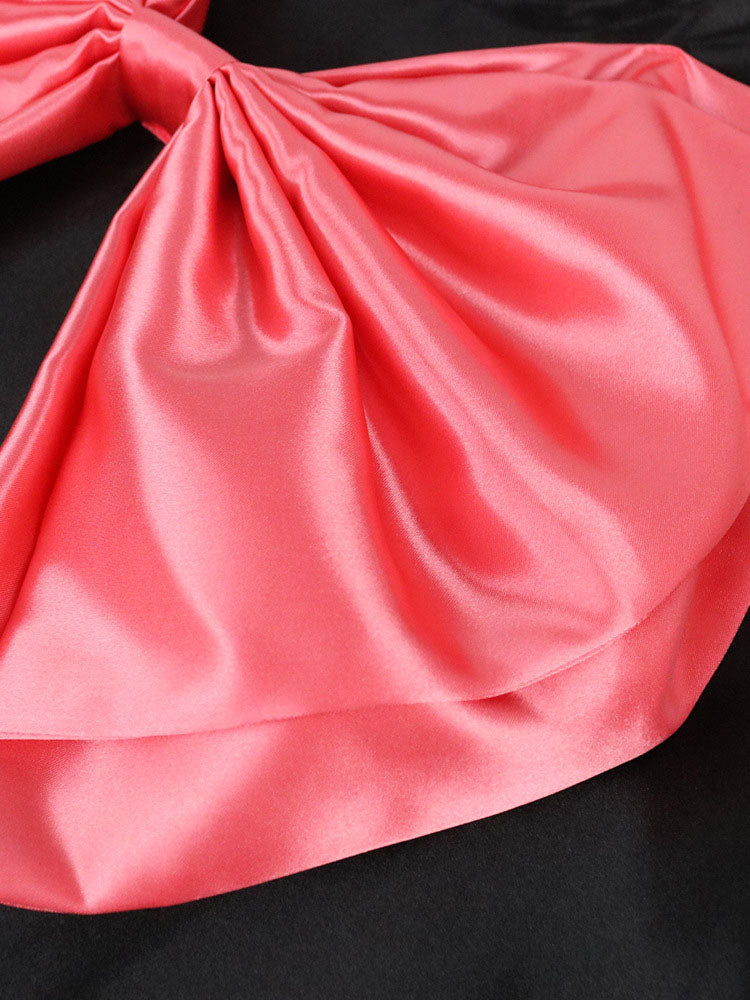 Detail shot of the satin pink bow on the black dress.