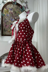 side view of a red and white polka dot halter dress with faux fur trim on a mannequin