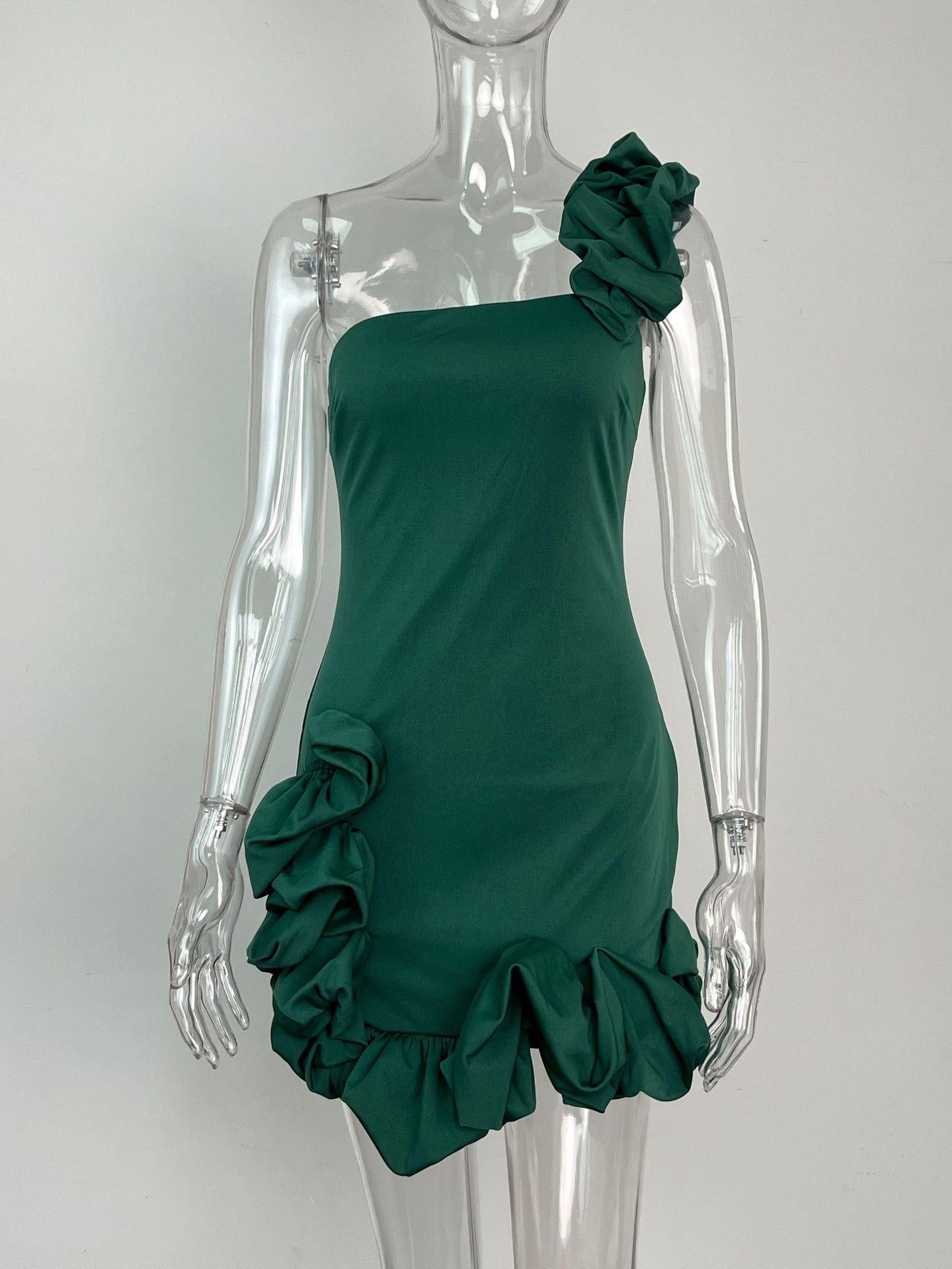Green one-shoulder mini dress with ruffle detailing on the shoulder and hip, displayed on a mannequin.