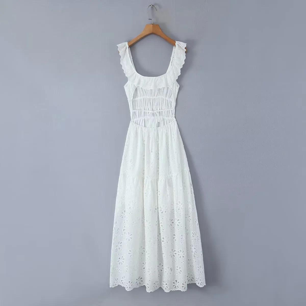 Back view of a white eyelet maxi dress hanging on a wooden hanger against a grey background