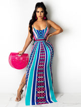 Woman wearing a colorful geometric print maxi dress with spaghetti straps and a side slit, holding a pink fan-shaped bag.
