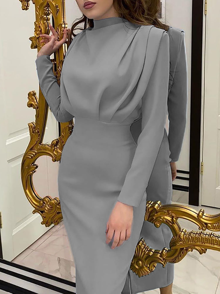 A woman wearing a grey long-sleeved draped neck sheath dress.