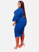 Side view of plus-size royal blue V-neck wrap dress with puff sleeves and self-tie belt