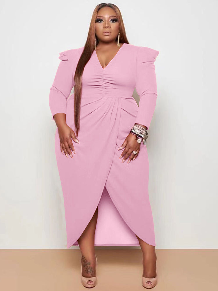 Woman wearing a pink ruched V-neck sheath dress with an asymmetrical tulip hem and puffed shoulders.