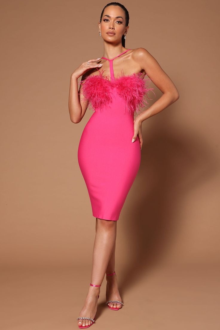 Woman wearing a hot pink bandage dress with feather trim and halter neckline