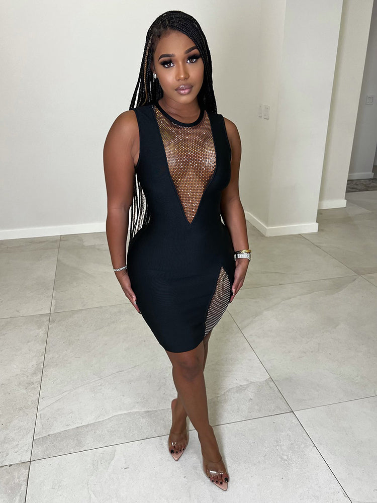 Woman wearing a black sleeveless bodycon dress with sheer mesh neckline and high slit embellished with rhinestones