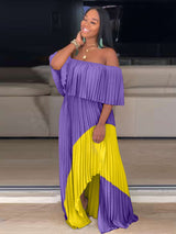Woman smiling and posing in a purple and yellow off-the-shoulder pleated maxi dress.