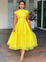 woman in yellow off-the-shoulder midi dress with tulle overlay