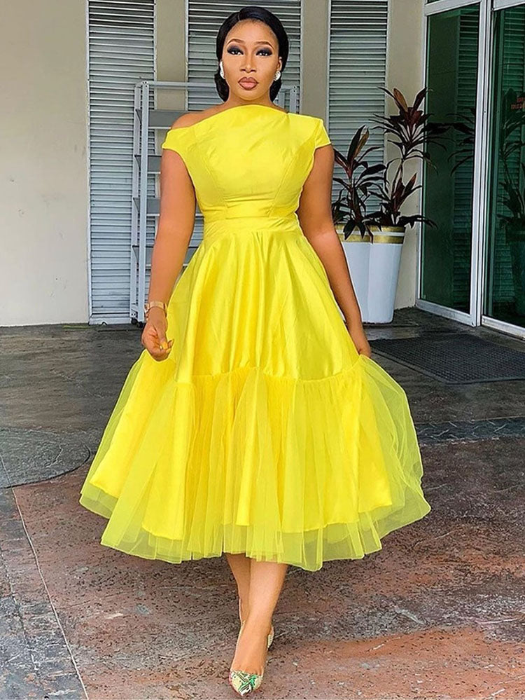 woman in yellow off-the-shoulder midi dress with tulle overlay