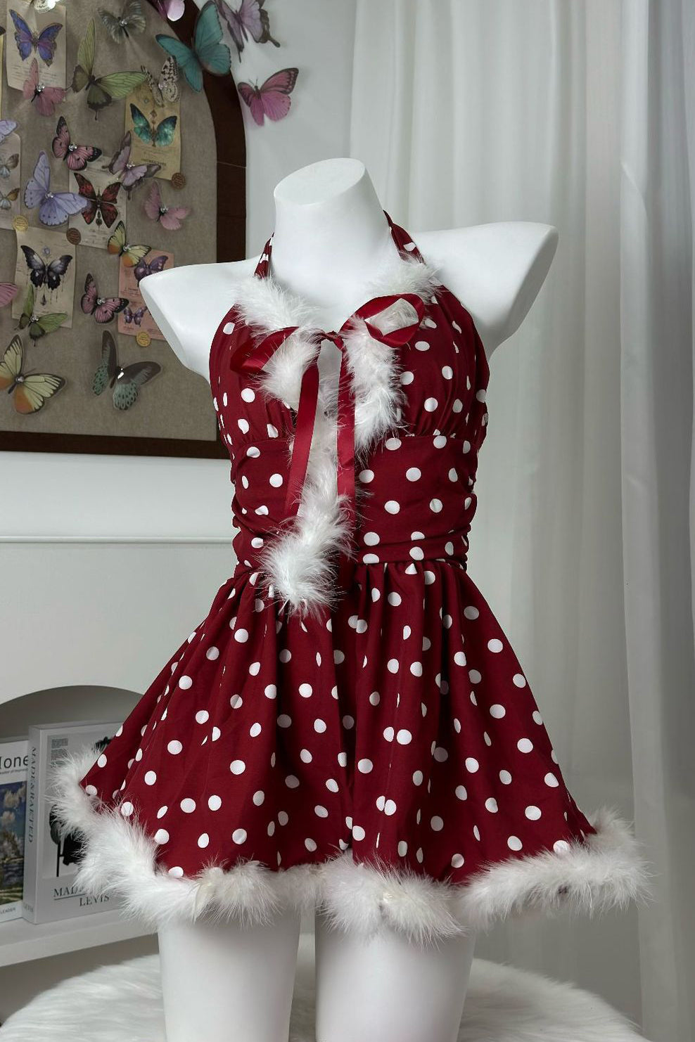 front view of a red and white polka dot halter dress with faux fur trim