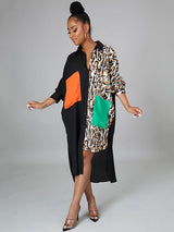 Full-length view of a woman in a black and leopard print color-blocked shirt dress with asymmetrical hem.