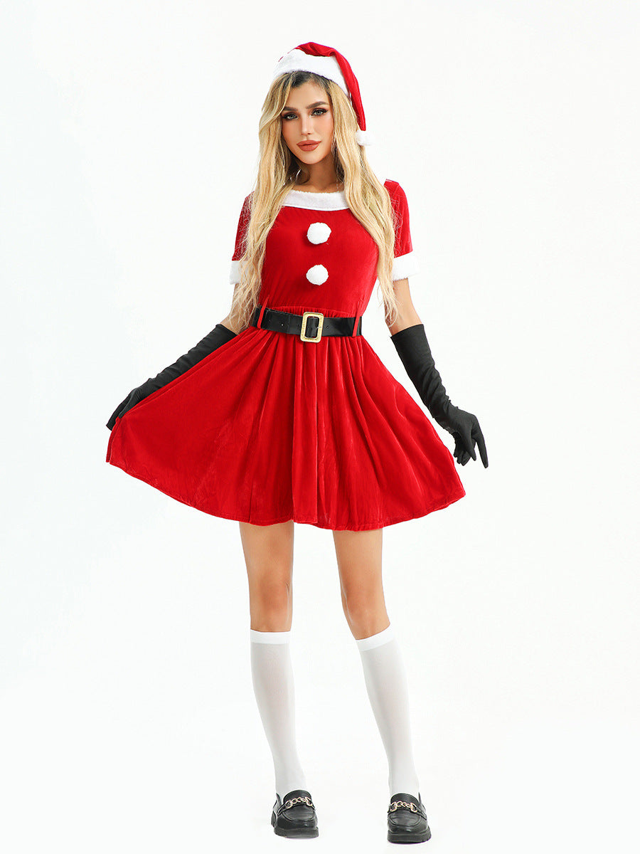 Woman in a festive red velvet Christmas dress, posing with her hands on her hips.