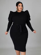 Front view of a woman in a black puff sleeve midi dress
