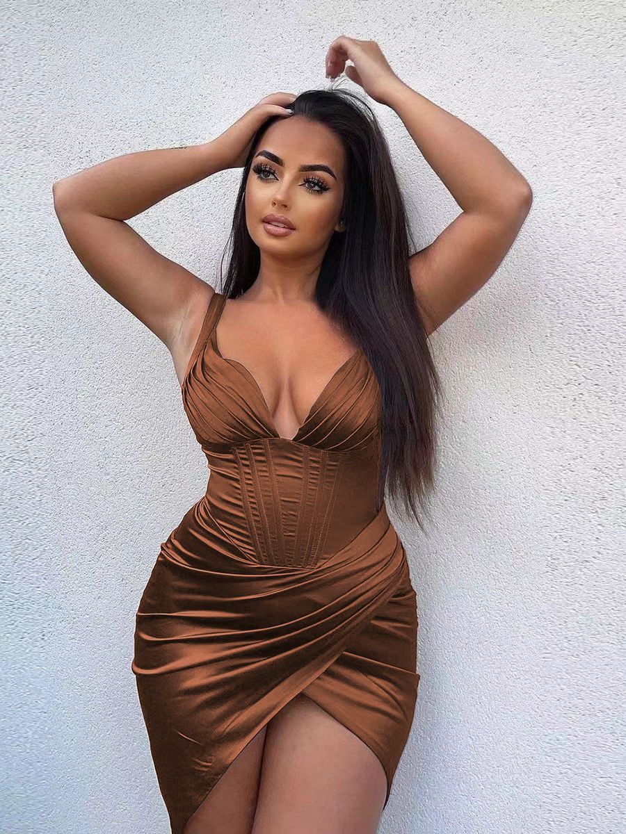 Woman with dark hair in a brown satin dress with a plunging neckline and high slit.