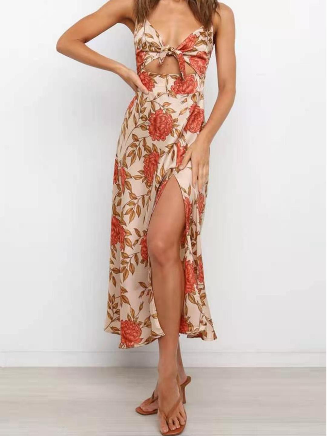 Woman wearing a floral print A-line midi dress with a plunging neckline and tie detail.