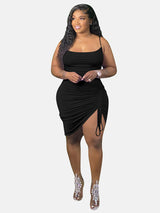 Woman wearing a black ruched midi dress with spaghetti straps and a drawstring detail.