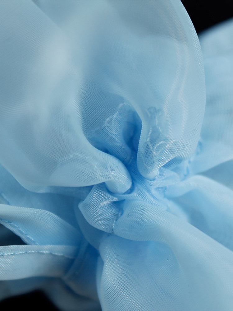 Close-up of the light blue sheer organza fabric with ruffles and ties on the sleeves