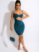 Woman wearing a teal ruched bodycon dress with a cut-out detail and twisted bust.