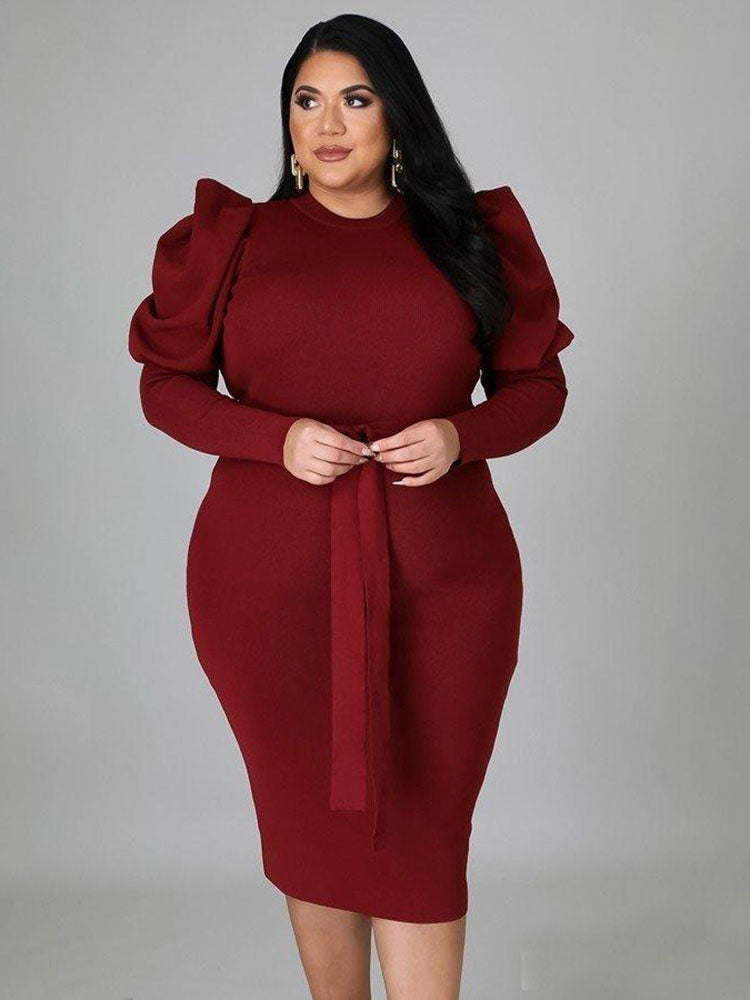 Woman posing in a burgundy knit dress with puff sleeves