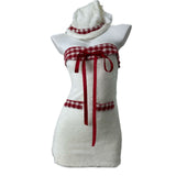 Front view of a white strapless dress with red plaid trim and red ribbon accents, displayed on a mannequin with a matching hat.