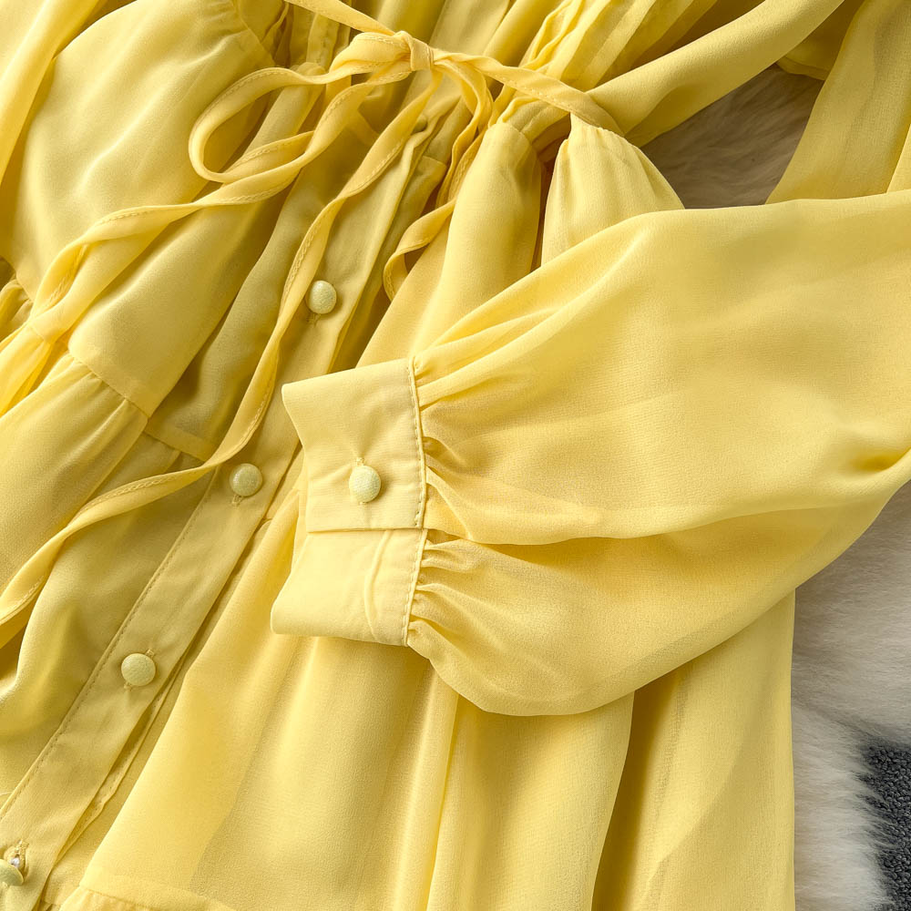 A woman wearing a chic pleated maxi dress with a tiered skirt and puff sleeves. - View 7 | Lwiis