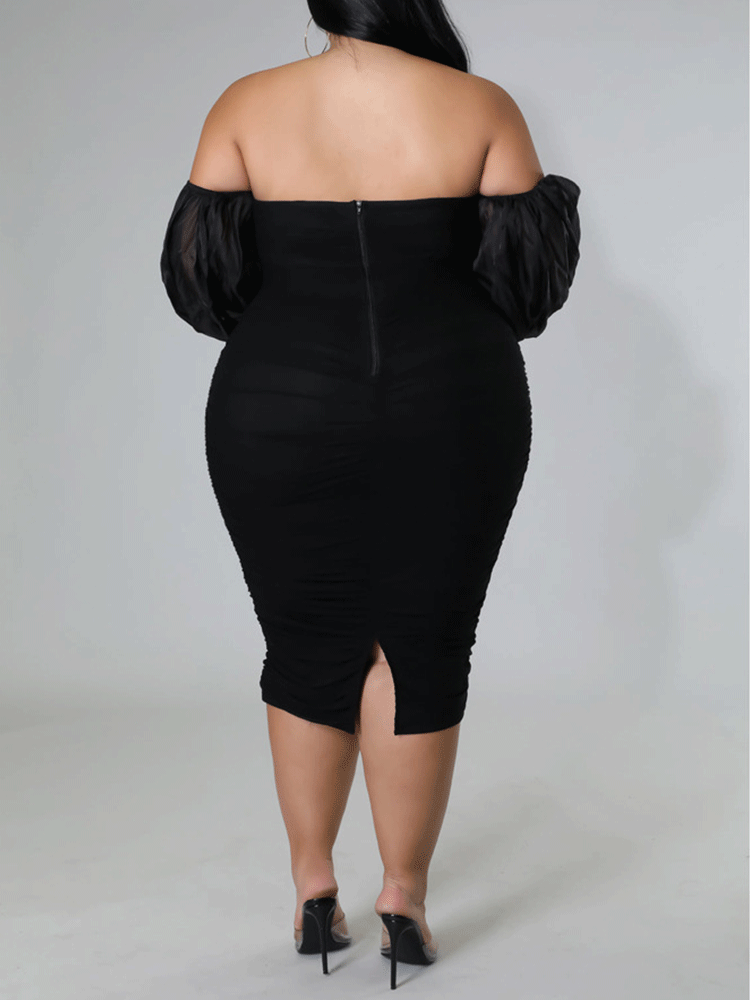 Back view of a woman in a black off-the-shoulder ruched midi dress with sheer puff sleeves.
