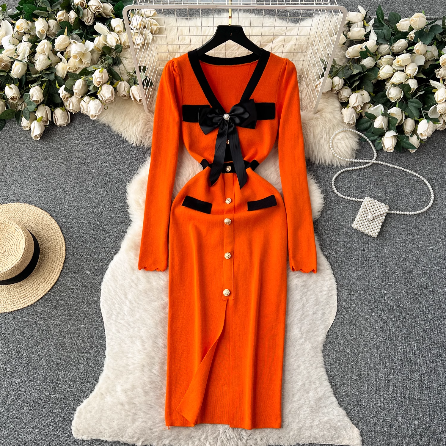 Orange knit dress with black trim and bow detail
