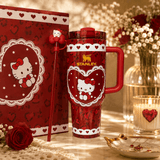 Red Stanley mug with Hello Kitty design next to a matching notebook on a decorative table.