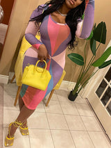 Woman wearing a long-sleeved, multi-colored geometric print bodycon dress with a crew neck, holding a yellow handbag and yellow strappy heels.