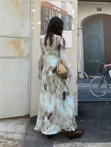 Back view of a woman in a tie-dye maxi dress, highlighting the length and the tie-dye pattern.