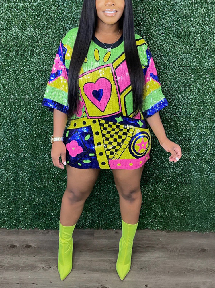 Woman with long black hair wearing a colorful sequined t-shirt dress with geometric patterns and a heart graphic, paired with neon yellow ankle boots.