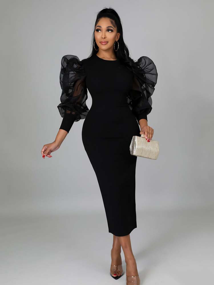 Woman wearing a black midi dress with sheer puff sleeves