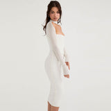 Side profile of a woman in a white sheer long-sleeve midi dress with a corset bodice and choker neckline.