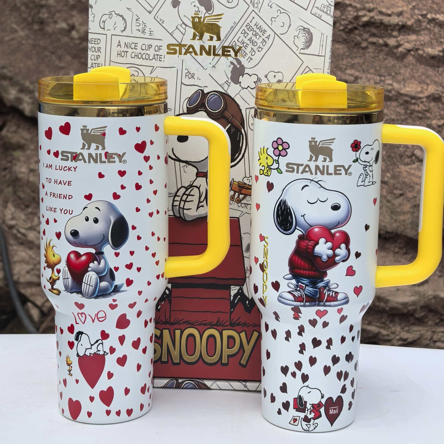 Snoopy Stanley 40oz insulated tumbler set with yellow handle and lid, holding hearts, includes matching Peanuts gift box