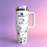 Stanley 40oz insulated tumbler with Snoopy and Woodstock illustrations, hearts and playful icons, white ergonomic handle
