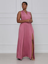 Woman wearing a dusty rose maxi dress with a V-neck and high slit, posing with hands clasped.