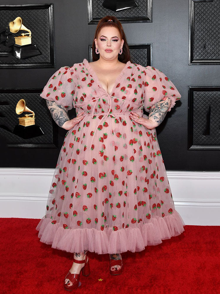 Woman in strawberry print dress posing