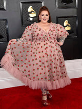 Woman in strawberry print dress on red carpet