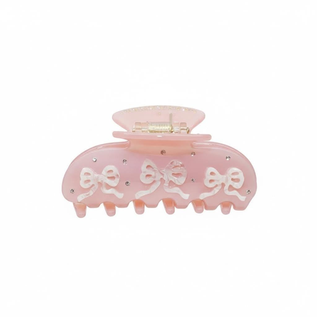 Pink hair claw clip with white 3D bows and rhinestones on a white background