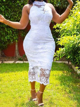 Woman wearing a white lace bodycon midi dress with a halter neckline, standing in a garden.