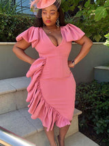 woman in a pink ruffled dress with hands on hips
