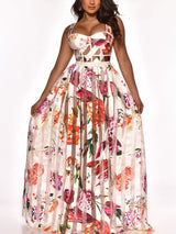 Woman posing in a white floral and striped maxi dress against a white background.