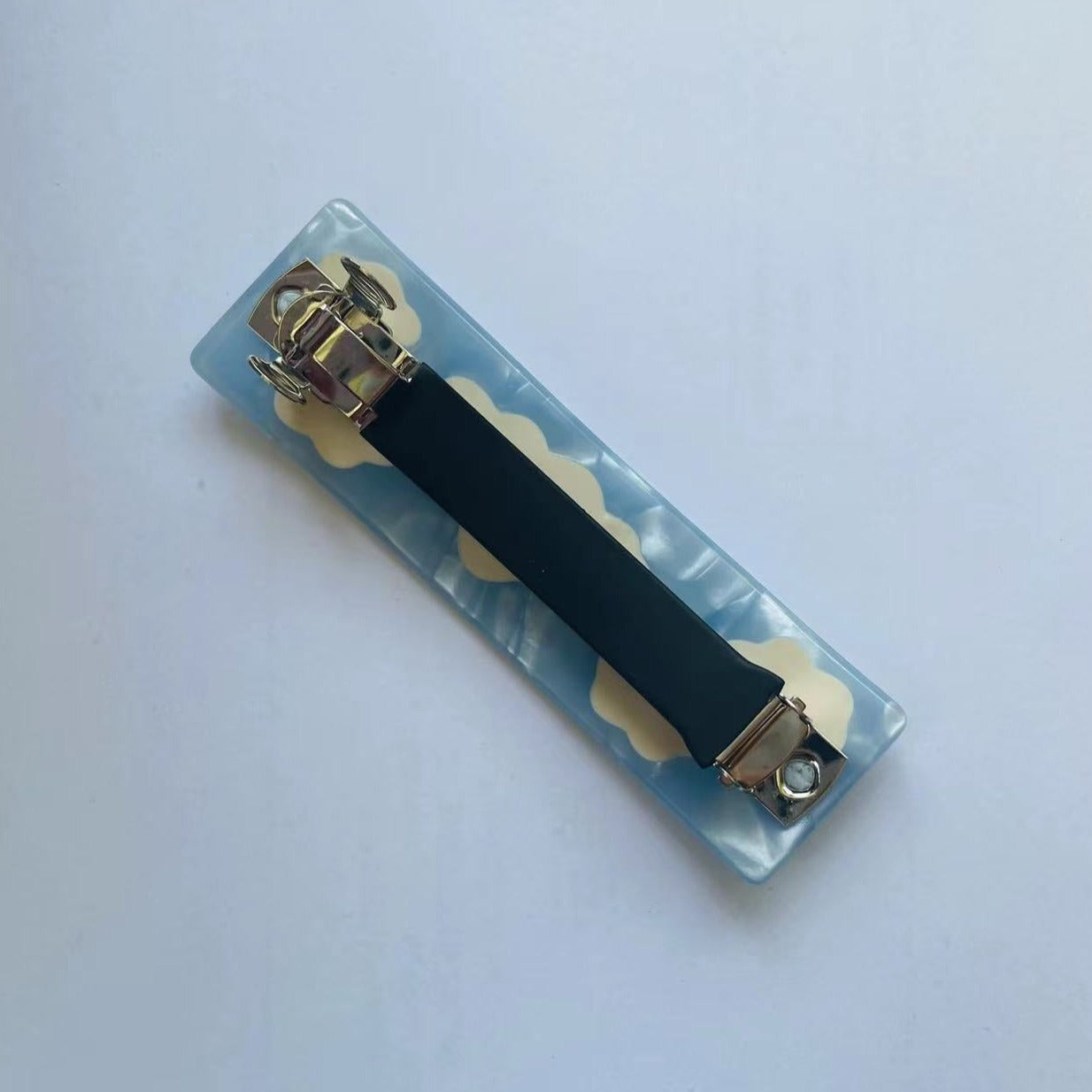 The underside of the barrette showing the metal clasp mechanism.